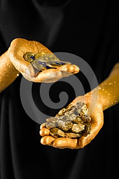 Woman with bitcoins and gold nuggets on black background, closeup