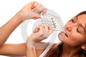 Woman bite the pack of medicine aspirin tablets