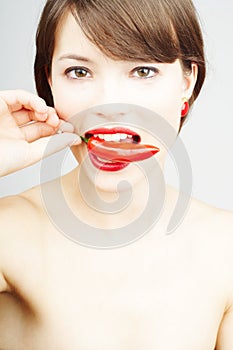 Woman biting a chili pepper