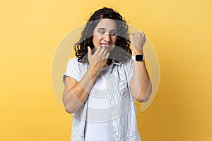 Woman biting finger nails and looking at her wrist clock with anxious, worried about deadline.