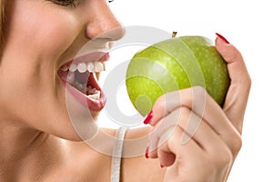 Woman biting green apple with heathy teeth