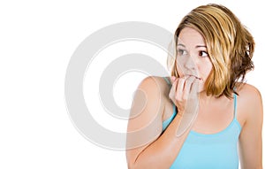 Woman biting her nails and looking to the side with a craving for something or anxious