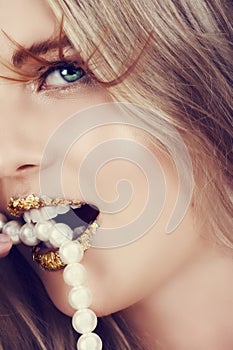 Woman biting pearls