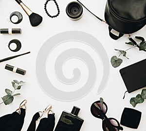 Woman black accessories grouped around empty space for text.