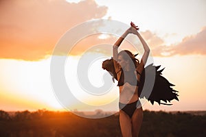 Woman with black angel wings at the hill