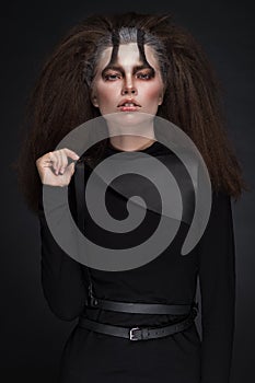 Woman in black clothes with expressive dark makeup