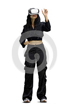 A woman in black clothes, on a white background, full-length, wearing VR glasses