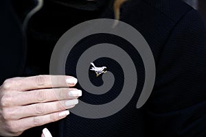 Woman in black with a diamonds bird brooch hand detail