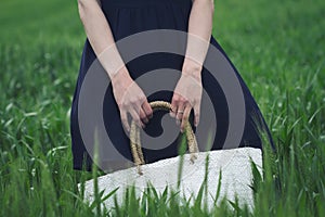 Woman with black dress in a field of green wheat