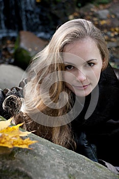 Woman in Black Fur Coat among Gray Stones