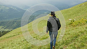 Woman in a black hat and a leather jacket walking