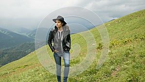 Woman in a black hat and a leather jacket walking