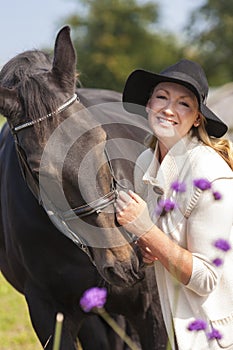 Woman in Black Hat Stroking Her Horse