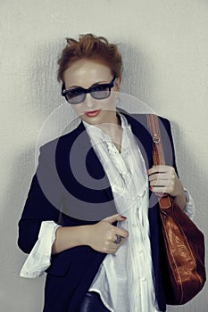 Woman in black jacket with leather bag.