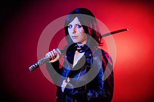 woman in a black leather jacket with a katana in her hands posing  on a dark background with red backlights