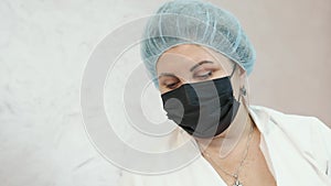 woman in a black mask sitting in the doctor's office and looking at the camera. Portrait of a man in a black medical
