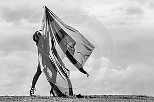 Woman in black overalls dancing with flying fabric