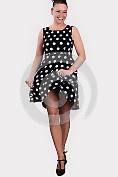 Woman in a black polka dot dress.