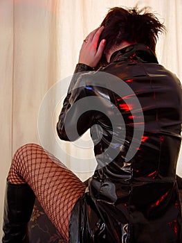 woman in black pvc coat and red fishnet stockings