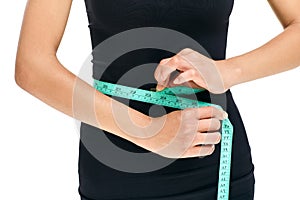 Woman in black shirt measuring waist with tape