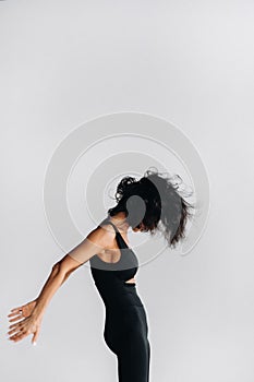 A woman in black sportswear is engaged in dynamic kali meditation in the Yoga hall