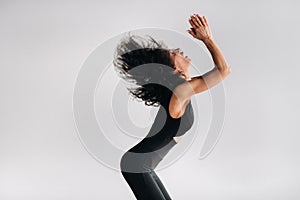 A woman in black sportswear is engaged in dynamic kali meditation in the Yoga hall