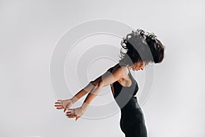 A woman in black sportswear is engaged in dynamic kali meditation in the Yoga hall