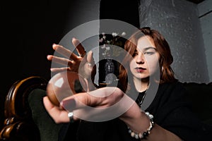Woman in black suit holding crystal ball