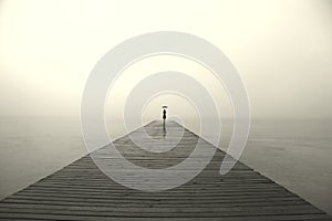 Woman with black umbrella looking infinity in a surreal place