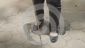 Woman with blindness disability crossing street walking on crosswalk and finding a guide braille blocks or tactile paving on