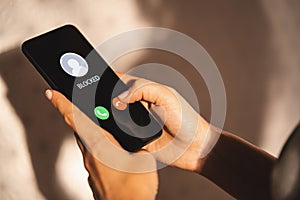 Woman Block a Phone Number or incoming Call from a anonymous stalker or Ex boyfriend. Stalking or bullying with phone concept. photo