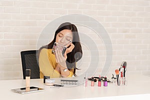 Woman blogger is showing how to make up and use cosmetics