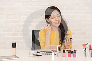 Woman blogger is showing how to make up and use cosmetics