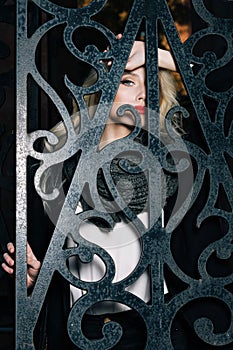 Woman with blond curly hair behind fence