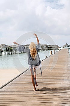 woman with blond hair in elegant beach clothes relaxing in