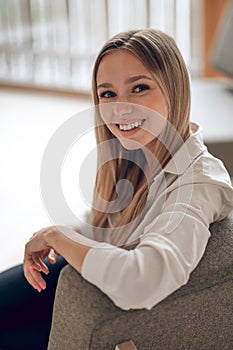 Woman with blond hair sitting in her modern appartement.