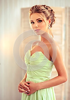 Woman with blond hair, wears in a wedding gown.