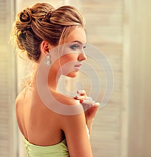 Woman with blond hair, wears in a wedding gown.