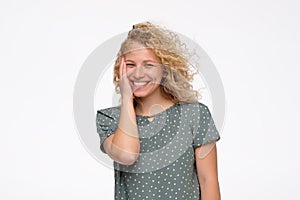 Woman with blonde curly hair smiling and laughing with wind effect