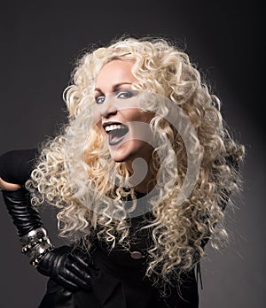 Woman blonde curly hairs, surprised with open mouth black lips,