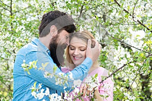 And woman in blooming garden. Young happy couple in love outdoors. Lovers on a walk in a spring blooming park.