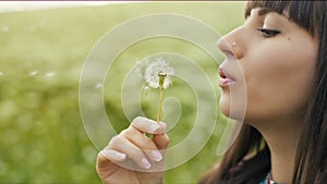 Woman blow dandelion