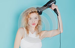 Woman blow drying her hair. Young girl with drying hair with hair dry. Health hair and beauty concept.