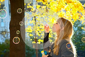 Woman blowing bubbles in park