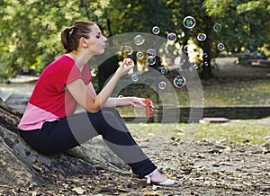 Woman blowing bubbles in park