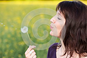 Woman blowing dandelion