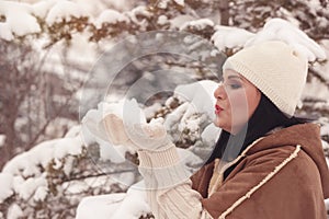 Woman blowing handful of snow