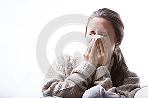 Woman blowing her nose because of a cold