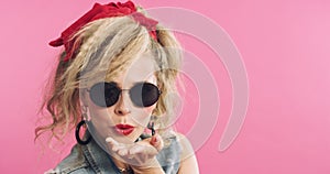 Woman, blowing kiss and retro fashion in studio, confident and pride for cool clothing by pink background. Female model