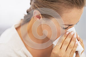 Woman blowing nose into handkerchief